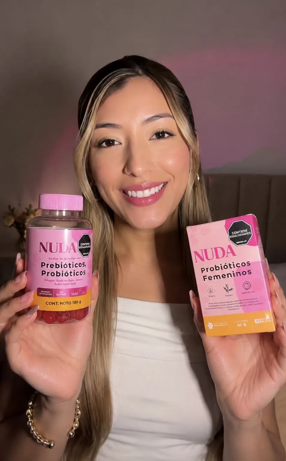 Mujer mostrando caja y frasco NUDA